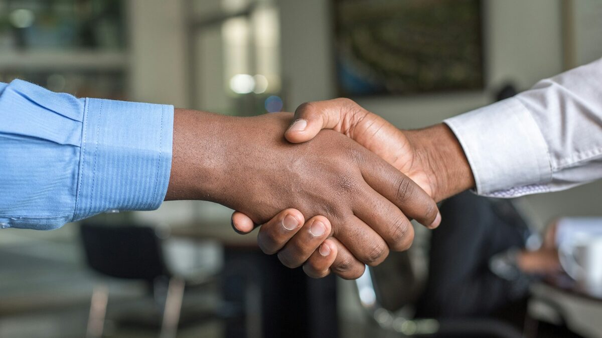 Changing employers in Canada: what your work permit really allows Foreign worker shaking hands with a new manager in a bright Canadian office, symbolizing a successful job change